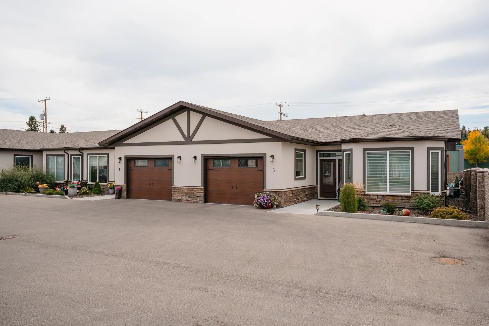 Two attached garages with wood-toned doors at Cornerstone Place, from the supplied project reference collection